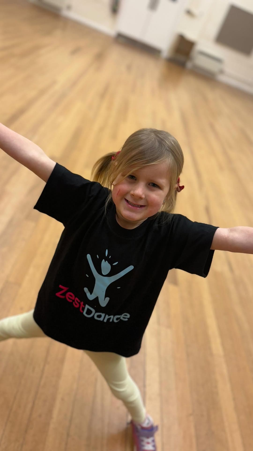 Young child standing with arms wide open, full of energy and joy