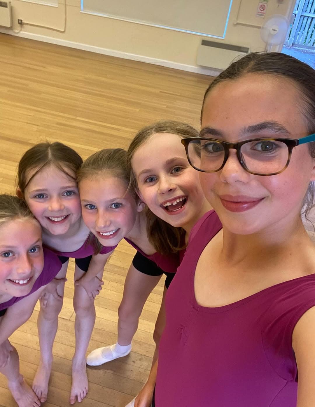 Dance teacher taking a selfie with smiling adult students after class